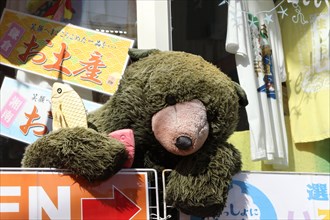 A large teddy bear in front of a souvenir shop