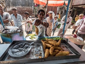 Vendor offers tasty fried snacks at a street food stall