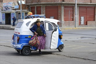 Old indigenous woman getting out of an autorickshaw