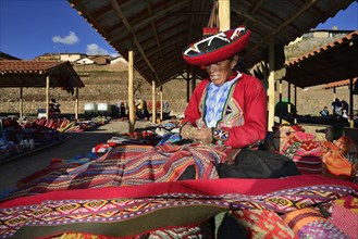 Indigenous old woman selling colorful blankets at the weekly market market
