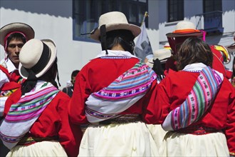Three indigenous woman in colorful costumes of a dance group
