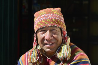 Indigenous man in colorful poncho and cap