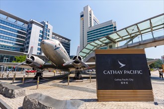 A Douglas DC-3 aircraft with registration VR-HDA in front of Cathay Pacific City at Hong Kong Airport