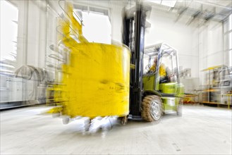 Forklift truck in motion in an industrial hall