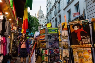 Street with souvenir shops on Montmartre with the Basilica Sacre-Coeur in the background