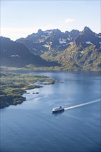 Hurtigruten boat on the fjord Raftsund with mountains