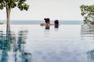 Mother and daughter by the pool