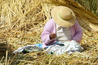 Indigenous woman embroidering on a Uro floating island