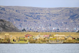 Floating island of the Uro with the city of Puno in the background