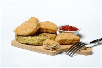 Meat substitute on wooden board and tray with ketchup