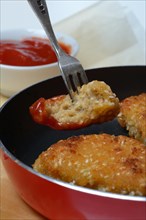 Meat substitute in pan and bowl with ketchup