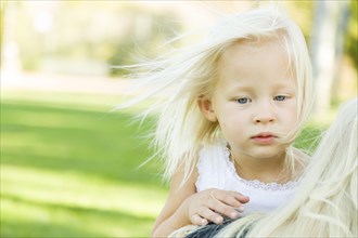 Melancholy portrait of cute little girl outside in park