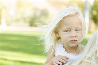 Melancholy portrait of cute little girl outside in park