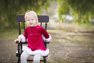 Adorable little girl sitting in her rocking chair outside