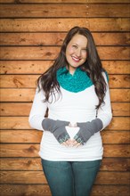 Beautiful young pregnant woman holds her stomach with love you mittens