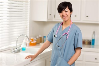 Smiling attractive mixed-race doctor or nurse in an office or laboratory setting