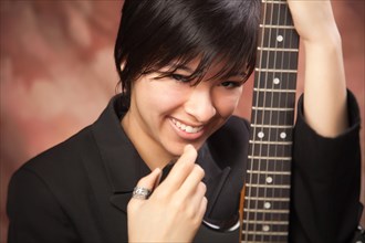 Multiethnic girl poses with her electric guitar