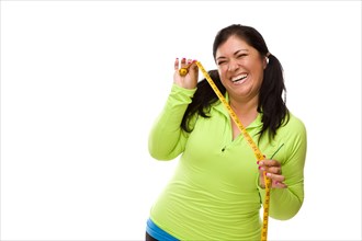 Attractive middle aged hispanic woman in workout clothes showing off her tape measure against a white background
