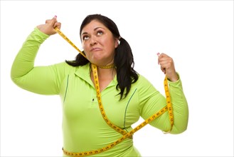 Attractive frustrated hispanic woman tied up with tape measure against a white background