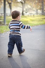 Happy young baby boy walking in the park