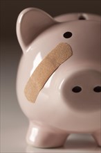 Piggy bank with bandage on face