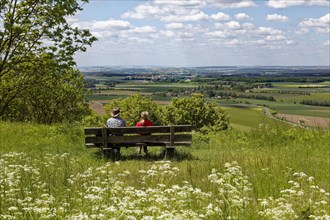 Couple on bench looks from the castle hill to Ruedenhausen