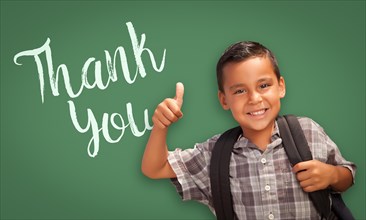 Cute hispanic boy with thumbs up in front of chalk board with thank you written on it