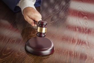 Judge slams his gavel and american flag table reflection