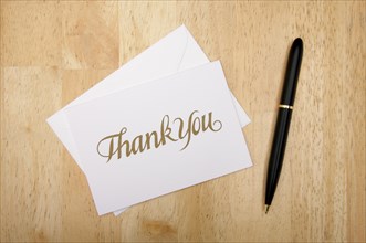 Thank you note card and pen on wood background
