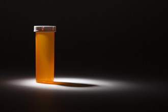 Empty medicine bottle under spot light abstract