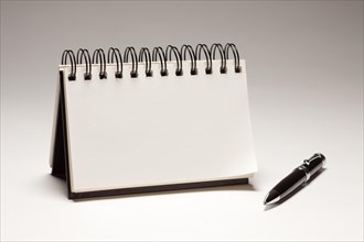 Blank spiral note pad and pen on a gradated background