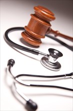 Gavel and stethoscope on gradated background with selective focus