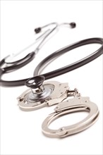 Stethoscope and handcuffs isolated on a white background