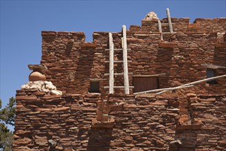 Southwestern hopi house 1905 architecture abstract with wooden ladders and clear blue sky