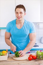 Preparing food cutting vegetables young man lunch in the kitchen healthy food vertical in germany