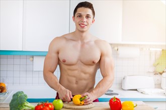Preparing food cutting vegetables young man lunch in the kitchen healthy nutrition text free space in germany