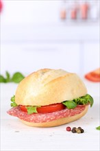 Roll sandwich baguette topped with salami ham text free space copyspace on wooden board in germany