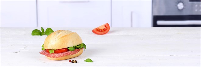 Roll sandwich baguette topped with salami ham text free space copyspace banner on wooden board in germany