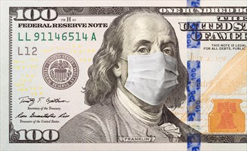 One hundred dollar bill with medical face mask on face of benjamin franklin