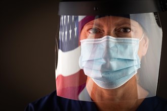 American flag reflecting on female medical worker wearing protective face mask and shield
