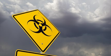 Bio-hazard yellow road sign against ominous stormy cloudy sky