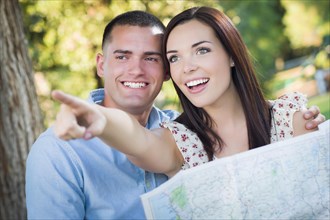 Happy mixed-race couple looking over A map and the sites outside together