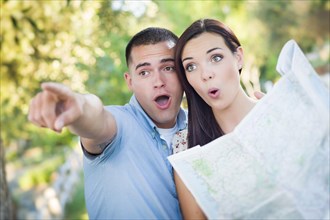 Happy mixed-race couple looking over A map and the sites outside together