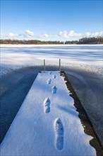 Footprints on jetty in snow