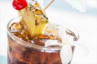 Ice cold mai tai cocktail drink with fruit and umbrellas at the bar