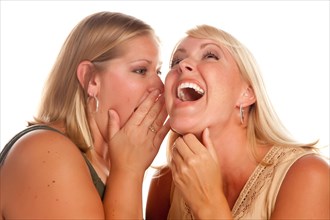 Two blonde woman laughing whispering secrets isolated on a white background