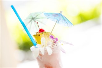 Fruity tropical drink with pineapple and umbrellas at the bar
