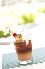 Ice cold mai tai cocktail drink with fruit and umbrellas at the bar