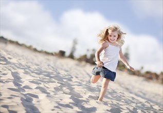 Adorable little girl having fun at the beach one sunny afternoon