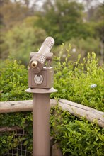 Public coin operated telescope and railing at wilderness overlook